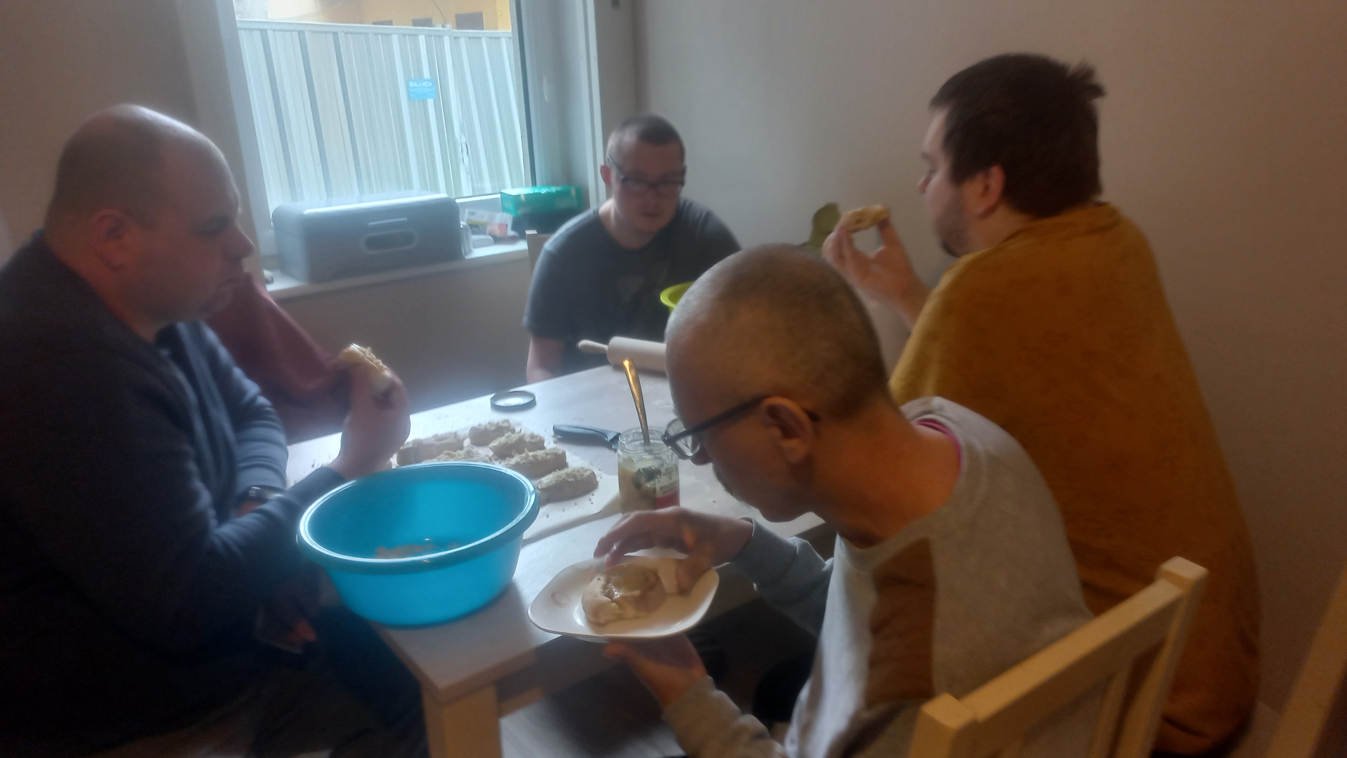 Mężczyźni jedzą przy stole dróżdżówki