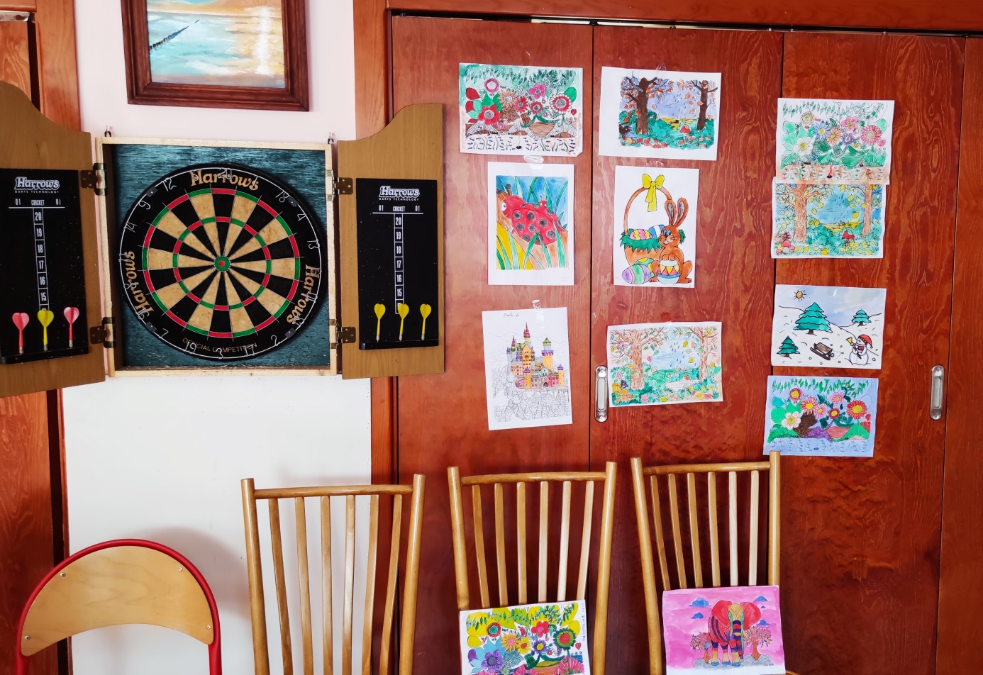 Ściana drewniana,z rysunkami i tablicą do gry w darta.