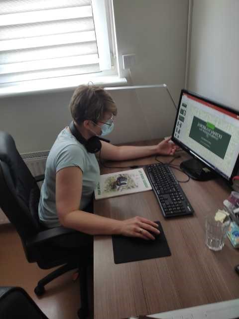 Kobieta przy komputerze przygotowująca wirtualną wystawę. 