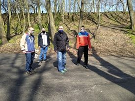 Czterech mężczyzn spacerujących po parku.