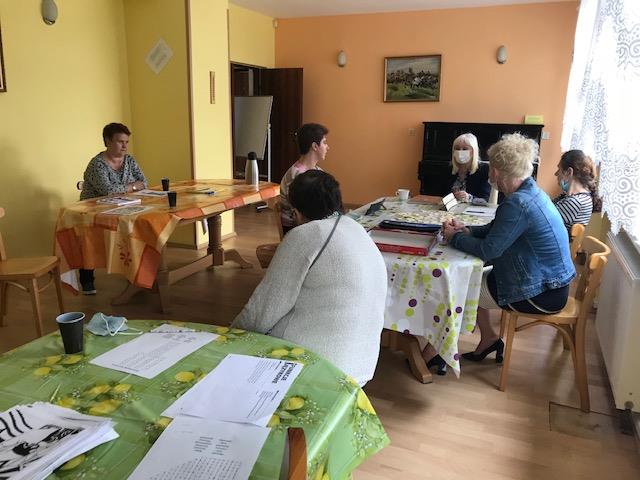 Sześć kobiet siedzących przy stole , które uczestniczą w pogadance nt. profilaktyki zdrowotnej.