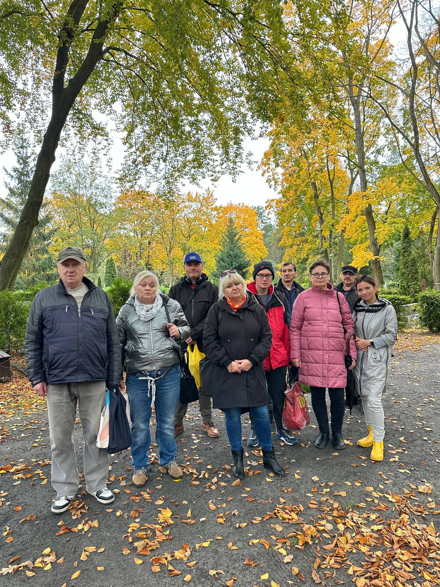 Grupa osób pogrążonych w zadumie stoi i pozuje do zdjęcia.