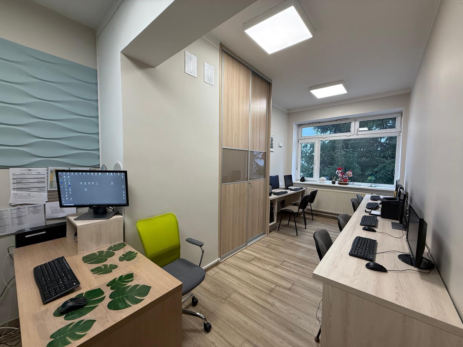 Sala terapeutyczna z trzema stanowiskami komputerowymi i sprzętem peryferyjnym oraz stanowisko pracy terapeuty