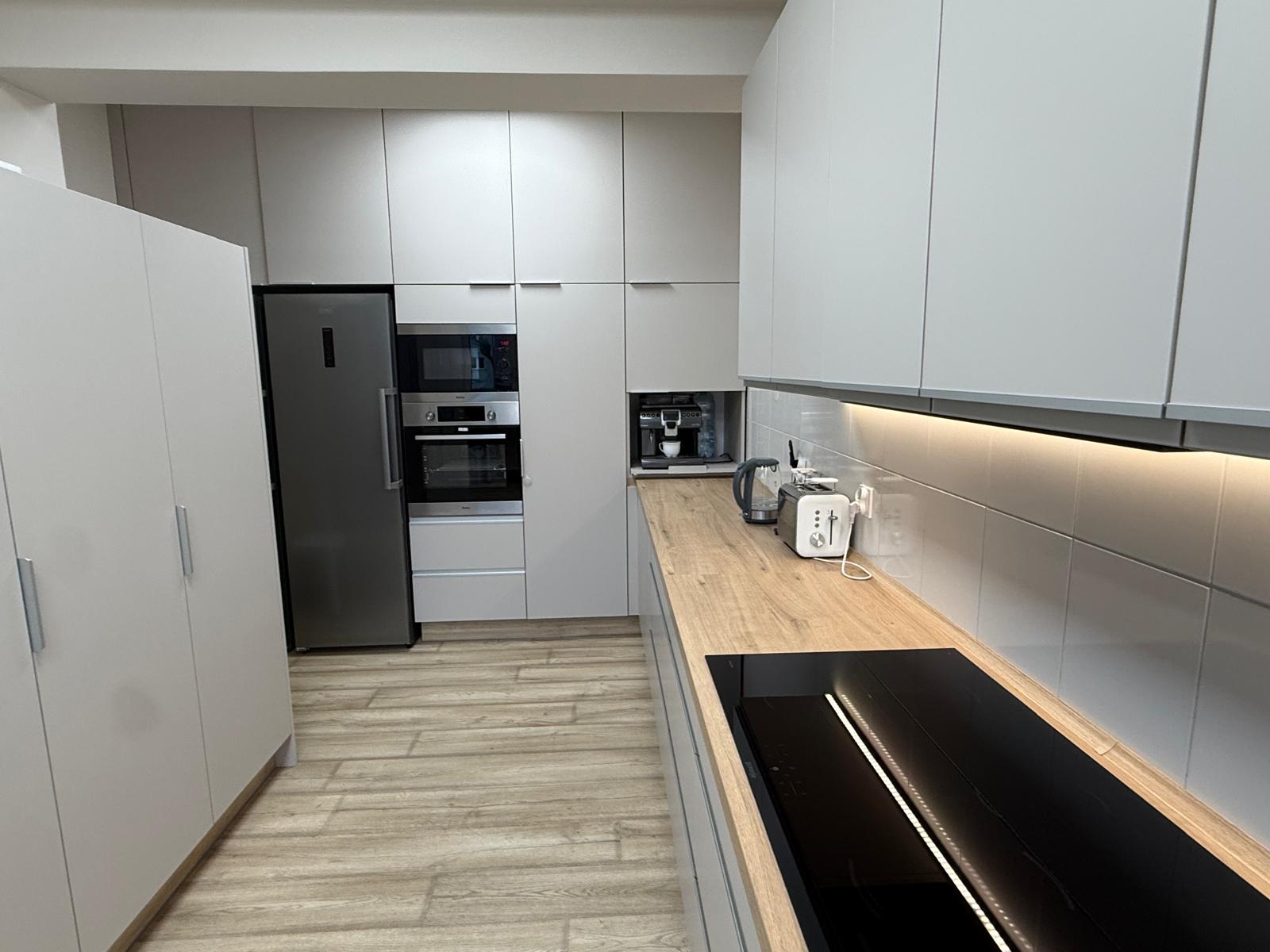 Pomieszczenie kuchenne z meblami i sprzętem agd.