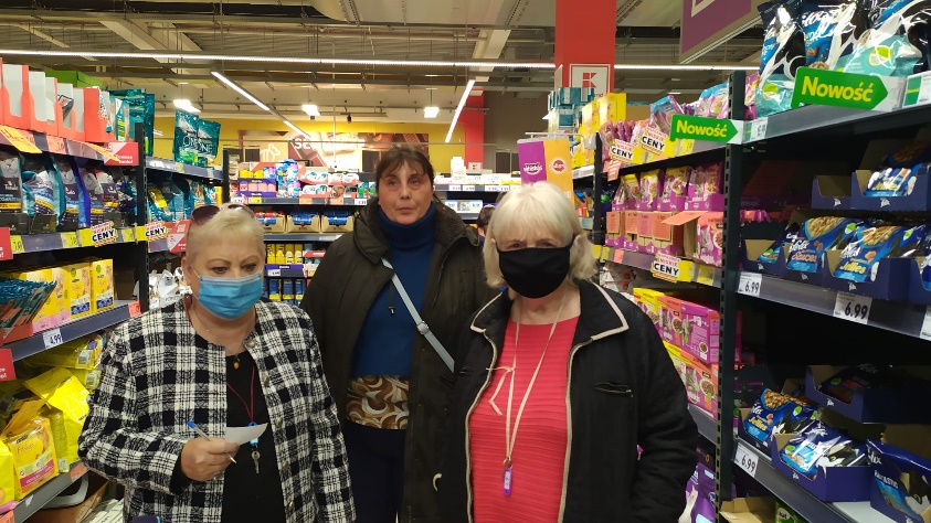 Trzy kobiety stoję w sklepie.