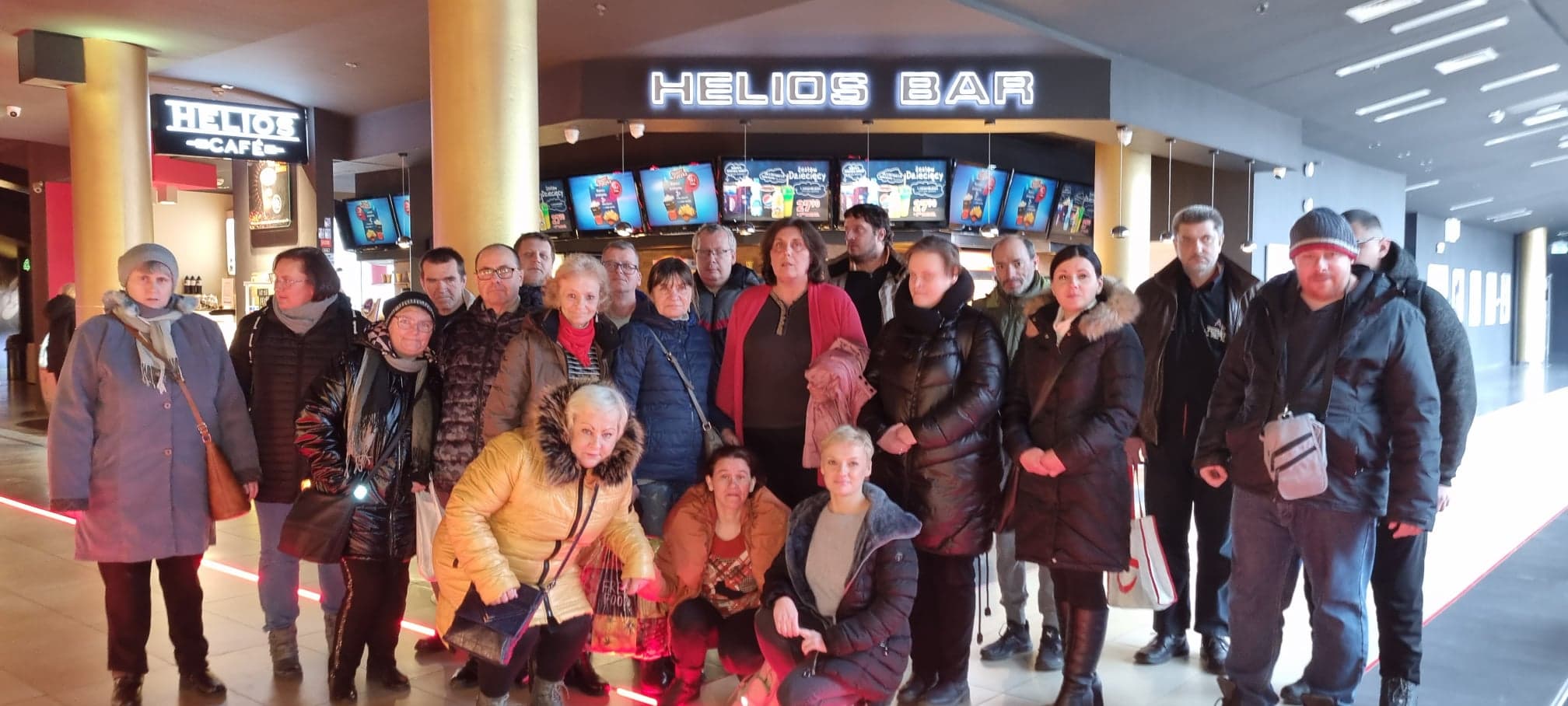 Grupa osób stoi do zdjęcia w holu kina Helios.