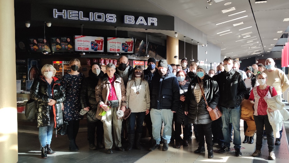 Grupa osób stojących przed wejściem do kina.