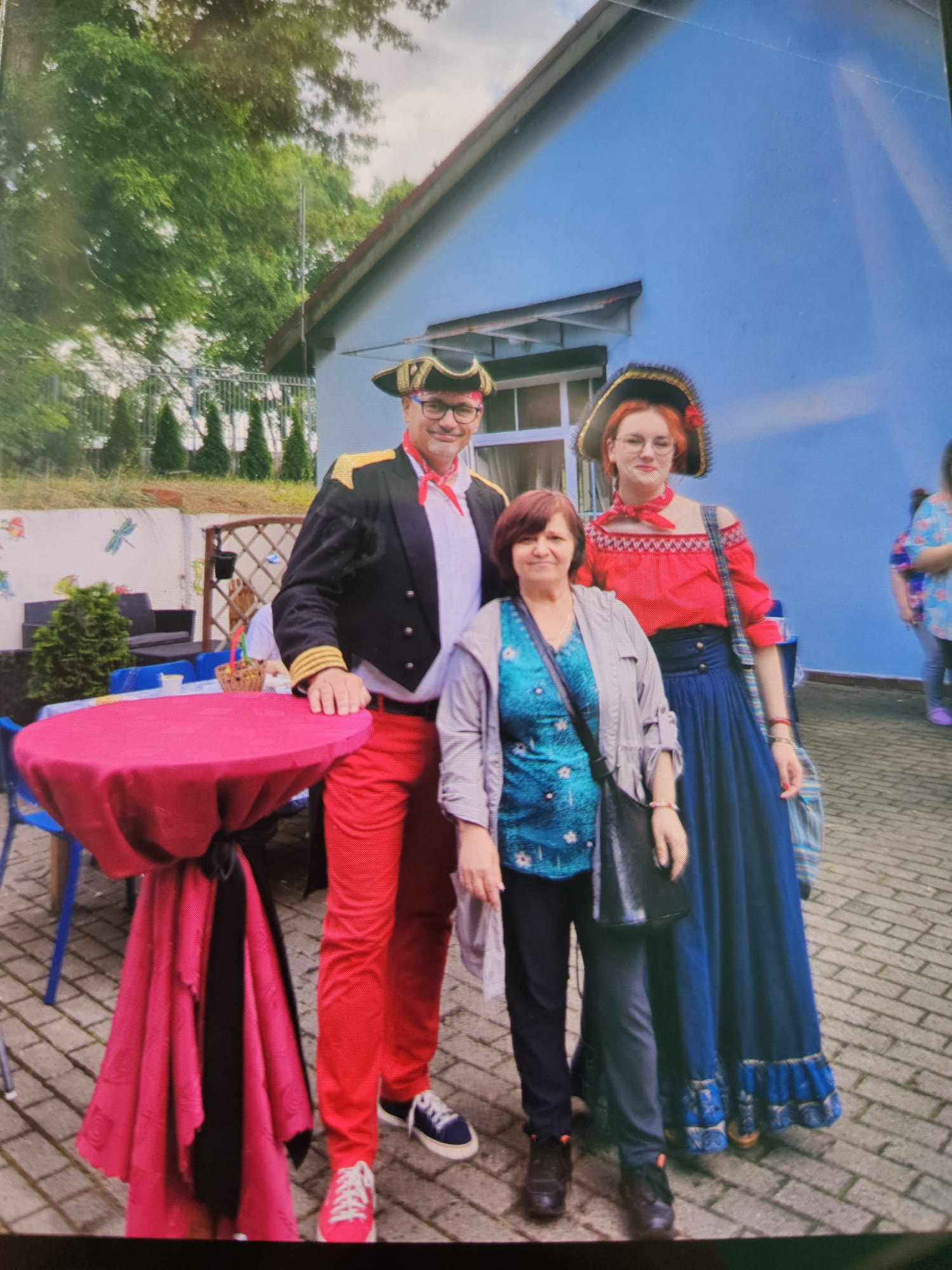 Kobieta stojąca z dwoma osobami przebranymi za piratów.
