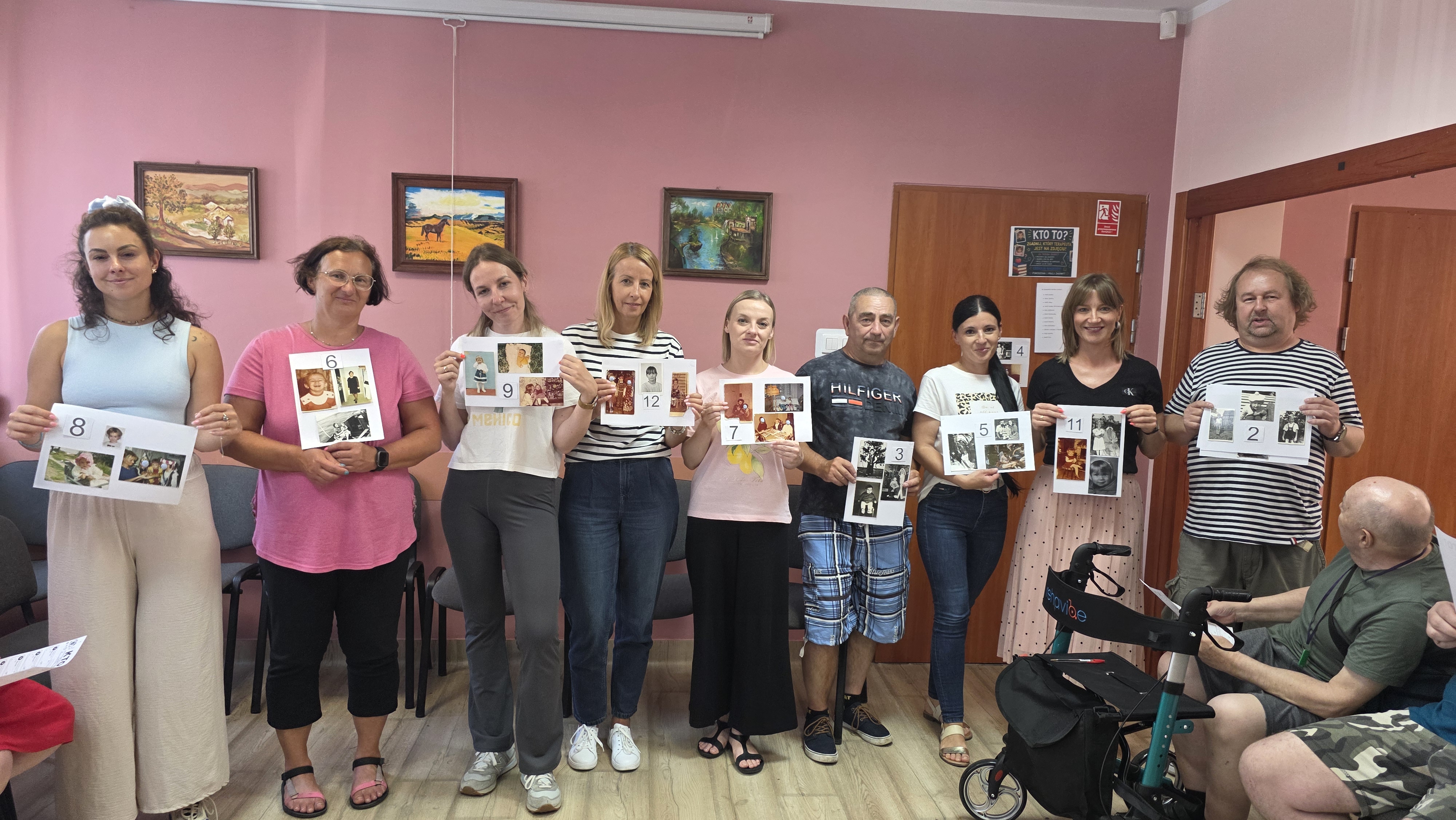 Grupa osób prezentuje innym swoje zdjecia z dzieciństwa.