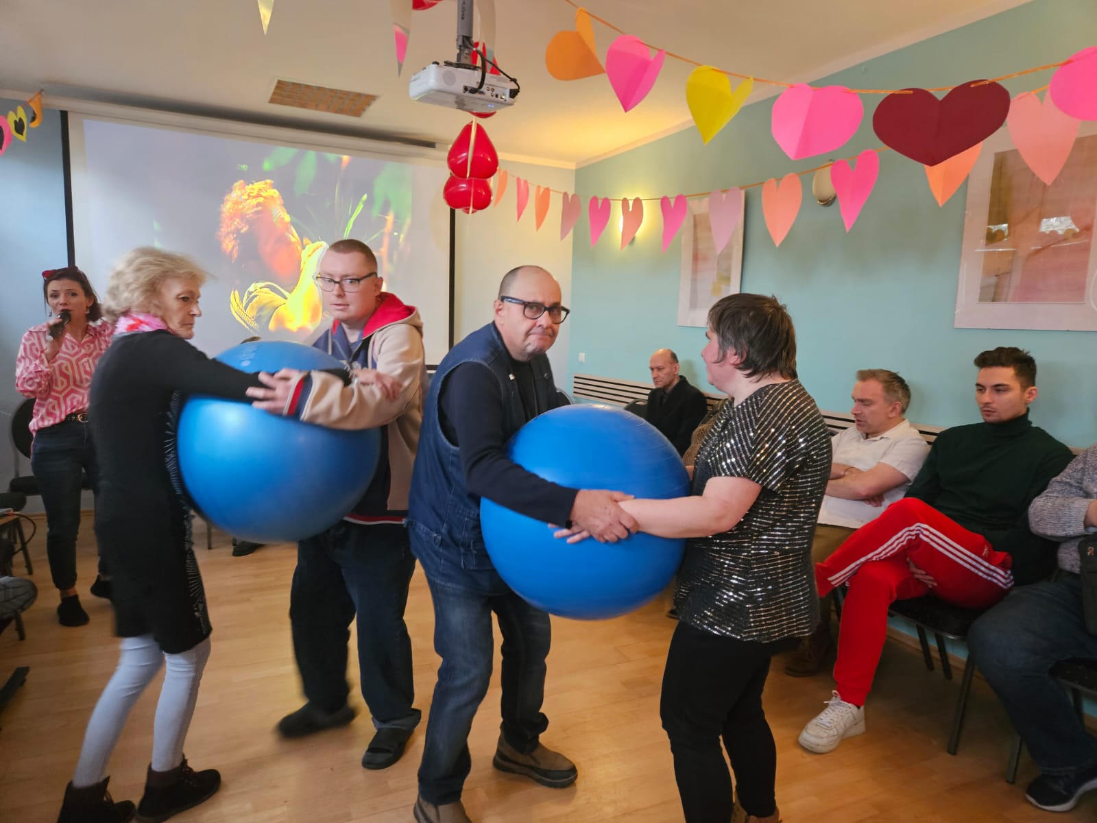 Grupa osób tańczy na Sali balowej.