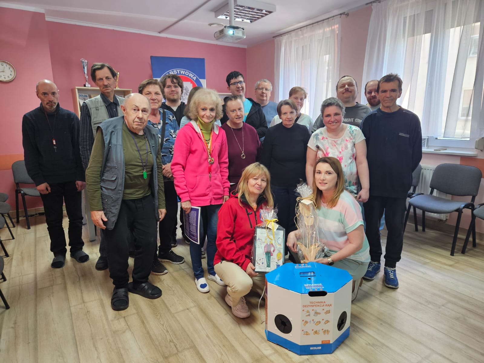Grupa osób pozuje do zdjęcia z prezenterem badania jąder.