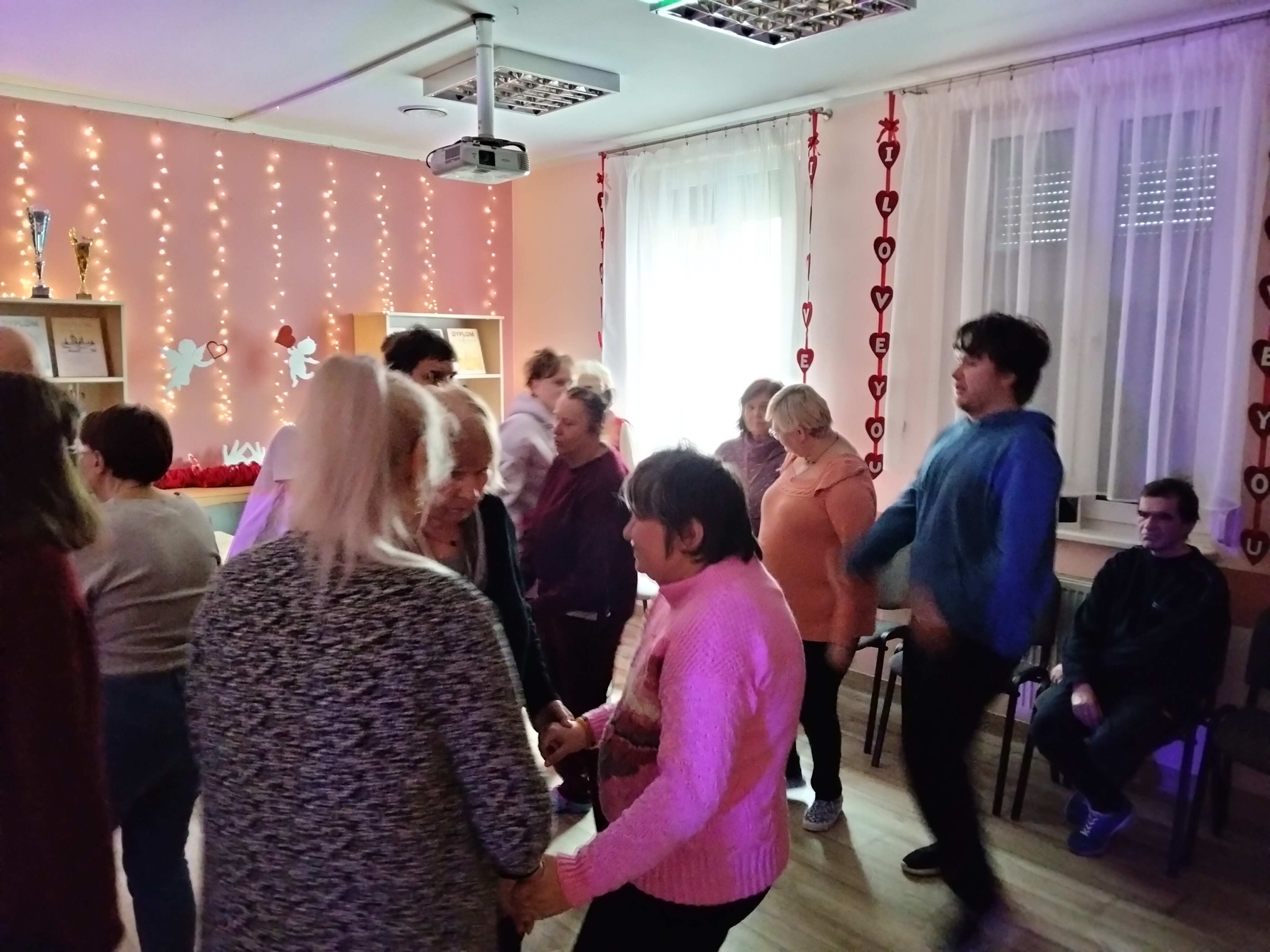 Kilka osób tańczy pośród innych tancerzy.