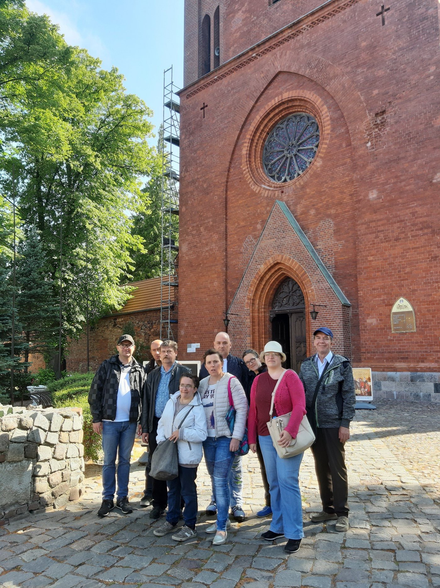 Grupa osób przed katedrą w Kamieniu Pomorskim. 