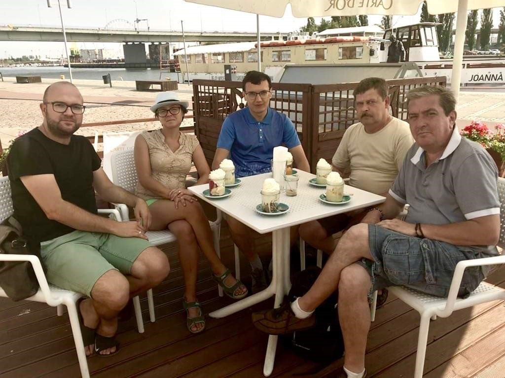 Grupa pięciu osób w kawiarni przy Bulwarach Szczecińskich przy stoliku z deserami. 