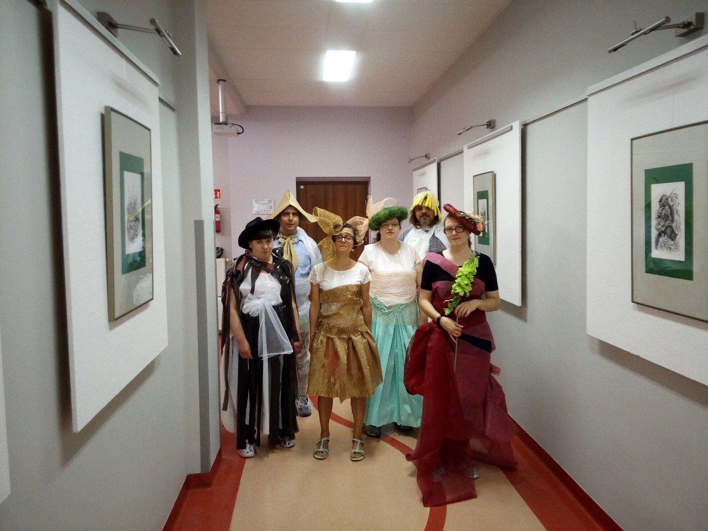 Grupa kobiet i mężczyzn prezentuje kostiumy na pokaz mody na wesoło.