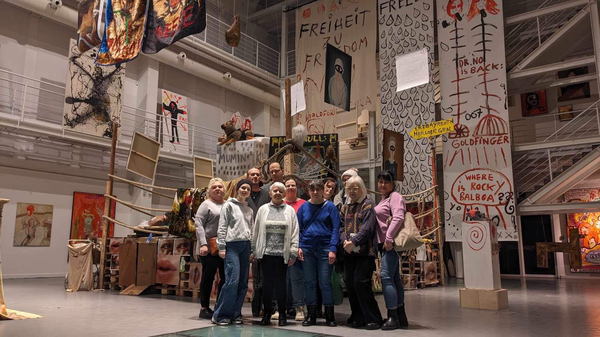 Grupa ludzi pozująca w galerii Sztuki Współczesnej