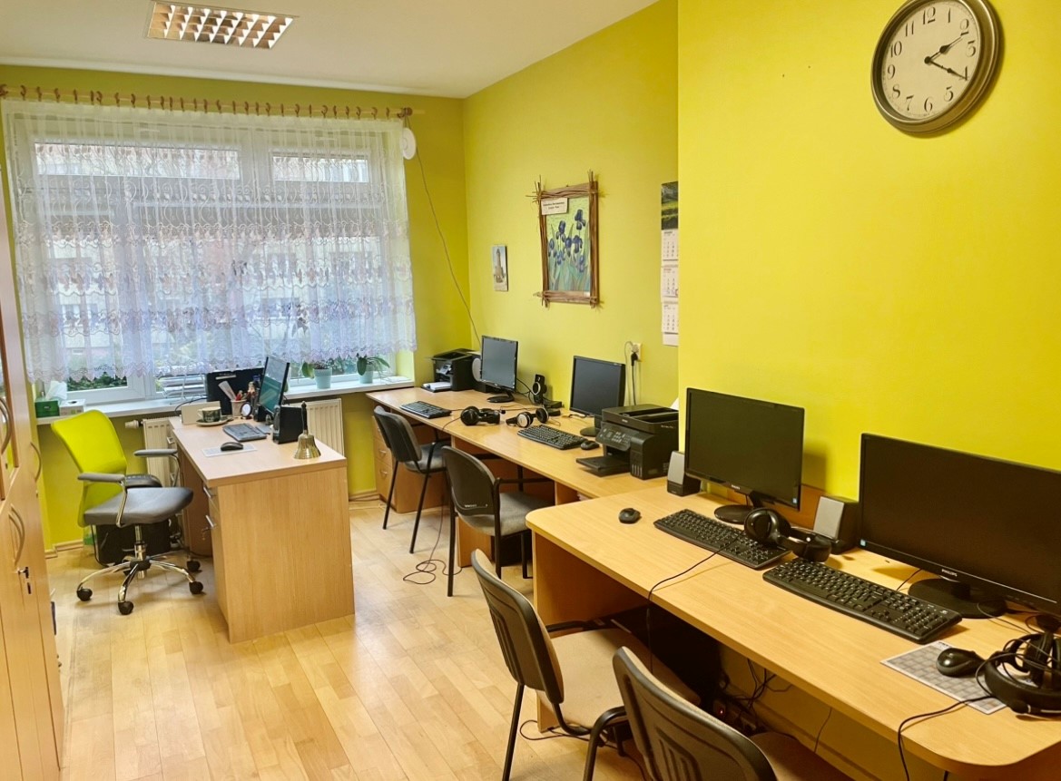 Sala terapeutyczna z trzema stanowiskami komputerowymi i sprzętem peryferyjnym oraz stanowisko pracy terapeuty