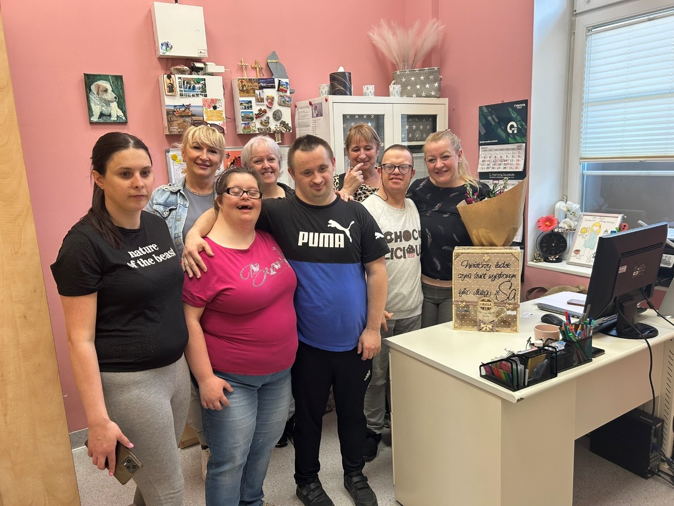 Grupa kobiet i mężczyzn pozuje do zdjęcia. 