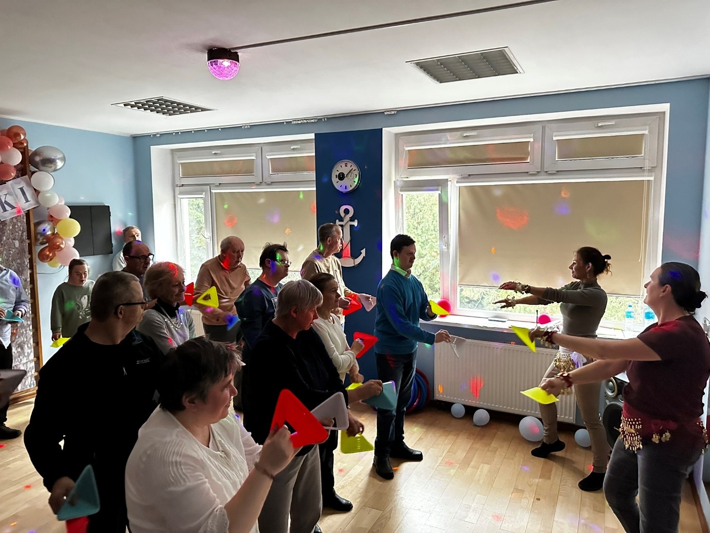 Grupa kobiet i mężczyzn podczas tańca.