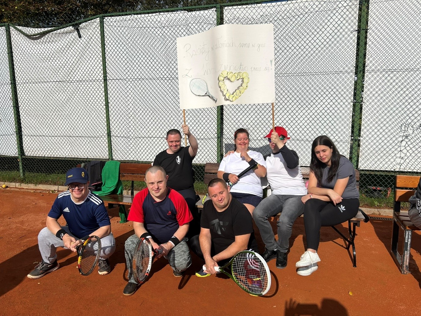 Pięciu mężczyzn i dwie kobiety pozuje do zdjęcia. Dwóch mężczyzn w dłoniach trzyma baner.  